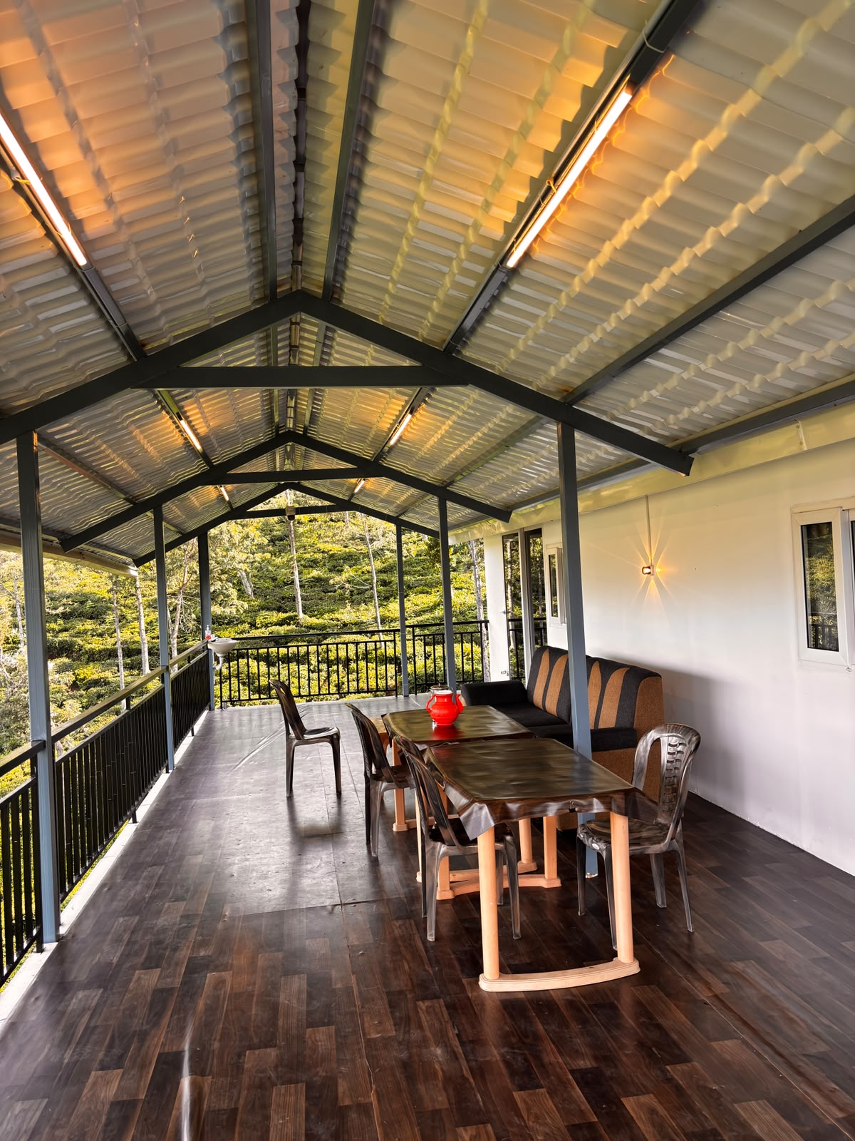 Covered verandah with seating overlooking tea gardens at MG Homestay Kotagiri