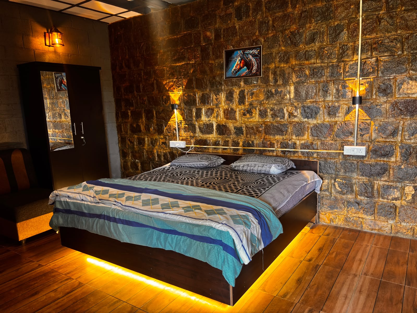 Room with natural stone wall and ambient lighting at MG Homestay in the Nilgiris